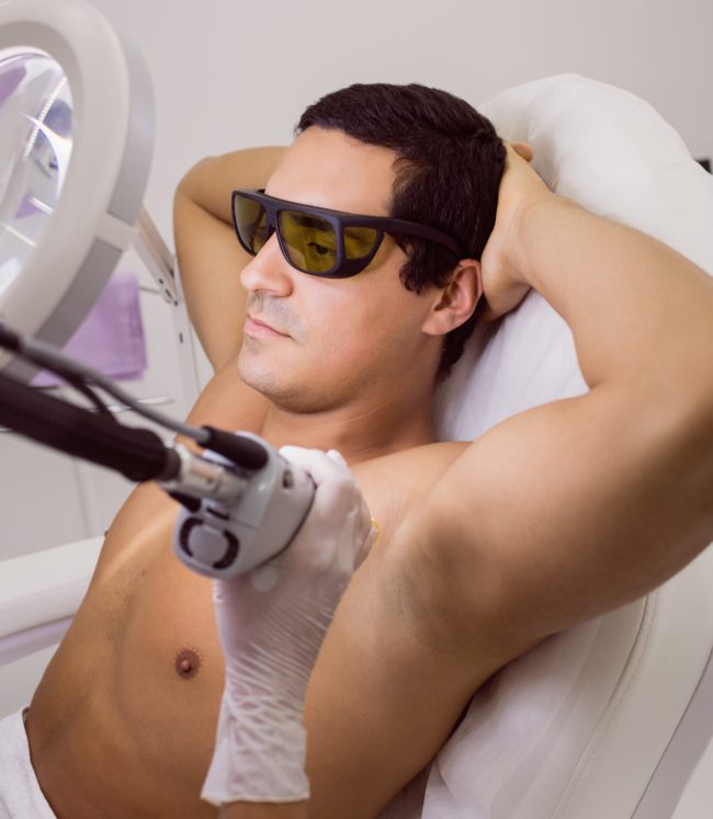 Doctor performing laser hair removal on male patient skin in clinic Doctor performing laser hair removal on male patient skin in clinic